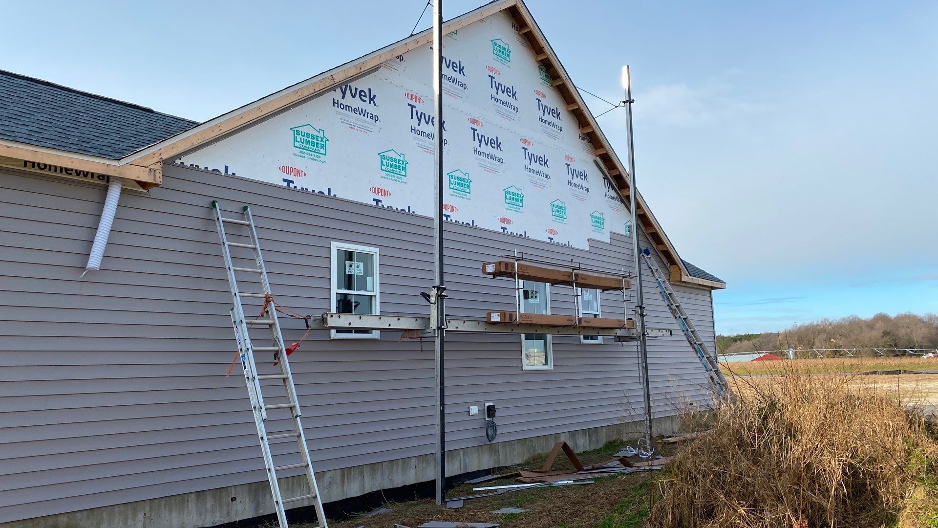 House under construction with Tyvek wrap and ladders